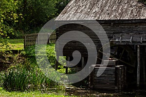 Old water mill made of wood with a wheel rotating from the flow of water