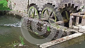 Old water mill still working. Wooden wheels of old mill are rotating. Postojna Cave, Slovenia, Europe