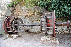 an old water pump in the rock side in front of a forest