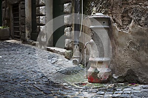 Old water tap in an alleyway in Rome, Italy