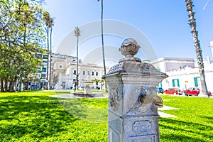 Old water tap on the virgilio park in brindisi, surrounded by buildings and cars. Park in the centre of brindisi old town photo