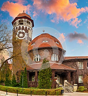 Old water tower and ancient building with a tiled roofs