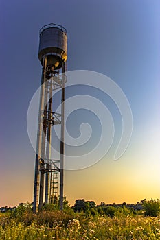 An old water tower in summer that stands on the outskirts of the village