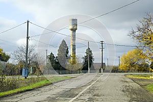 Old water tower in the village. Autumn landscape.