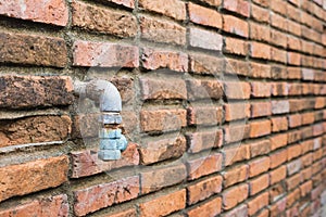 Old water tube woth the brick wall