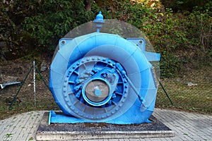 Old water turbine generator in blue spiral casing