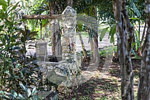 Old water well built of stone in the middle of the rainforest.