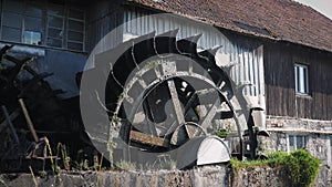 Old waterwheel mill. Water wheel turning water. Water falls on old water wheel. Old wooden mill with rotating wheel