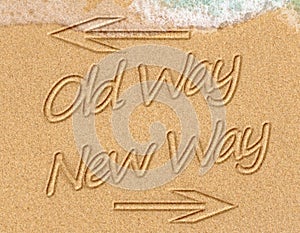 Old Way or New Way concept on the sand on the beach with the sea washing up the shore