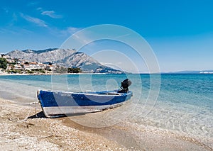 Old weathered boat on sandy beach on beautiful coast of adriatic sea in Croatia.