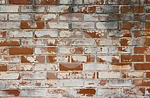 Old and weathered brick wall with traces of white paint. Old and rustic texture