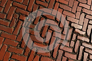 Old weathered and broken chipped brick road from naturally shiny brick pavement, clinker pavement texture