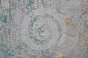 Weathered graffiti paint of silver color on concrete wall