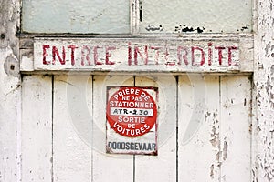 Old weathered door with red painted text and no parking sign