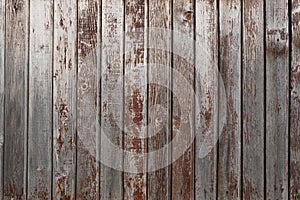 Old weathered faded shed wall made from vertically oriented wood boards. Vintage rustic textured timber background. Lumber texture