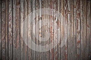 Old weathered faded shed wall made vertically oriented wood boards. Vintage rustic timber background wood texture grain vignetting