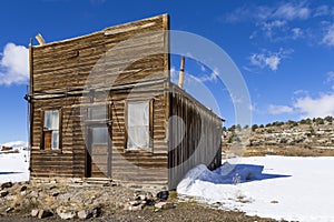 Old weathered Ghost Town buildings in the desert during winter with snow.