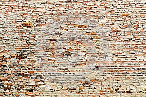 Old and weathered grungy red brick wall partly covered by excess cement and grey paint photo