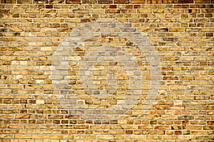 Old and weathered grungy yellow and red brick wall as seamless pattern texture wall background