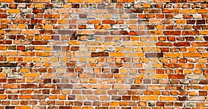 Old and weathered grungy yellow and red brick wall as seamless pattern texture surface background in wide banner format