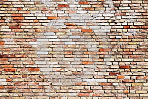 Old and weathered grungy yellow and red brick wall with visible crack as rustic rough texture background