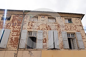 Old weathered house peeling paint open windows