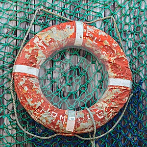 Old weathered lifebuoy on wooden wall