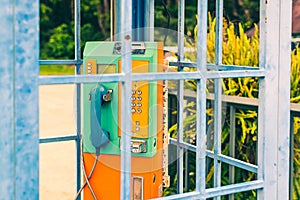 Old and weathered oldstyle plublic pay phone in phone booth