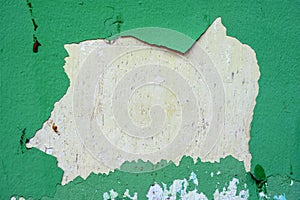 Old weathered painted wall background texture. Green dirty peeled plaster wall with falling off flakes of paint.Peeling paint