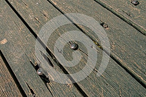 Old weathered planks wood floor with nails and cracks