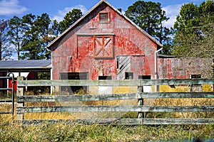 Old weathered Red Barn with Split-rail Fence in forefront photo