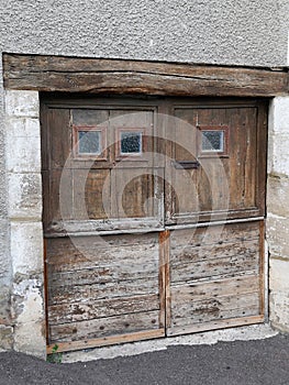 Old and weathered rustic wooden barn doors with rusty lock on ancient wood garage door house