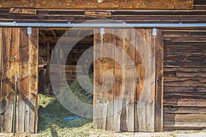 Old weathered sliding barn door hay sunlight