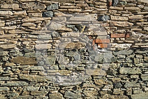 An old weathered stone wall with many small and large stones