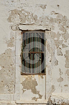 Weathered Wall With Barred Window and Shutters