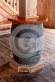 Old weathered wine barrel re-purposed and used as a table to set food and drinks on top of