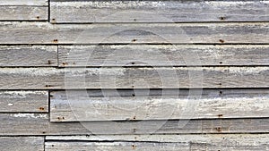 Old weathered wood board siding with faded white paint background