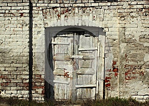 Old weathered wooden door in brick wall