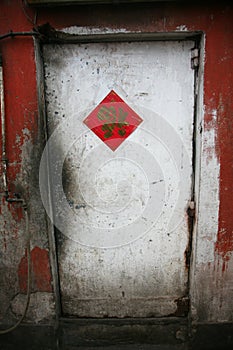Old and weathered wooden door with a Chinese character for Luck pasted on the door