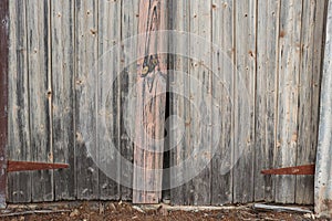 Old weathered wooden paling barn doors with rusty metal hinges
