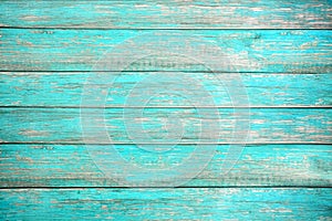 Old weathered wooden plank painted in turquoise or blue sea color.