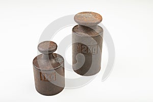 Old weights for weighing on a white table. Steel weights worth 1 and 2 kilograms