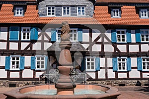 Old well in front of a half-timbered house in GrÃ¼nberg / Germany