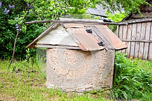 The old well, a rural landscape. An abandoned well in a thicket of green grass. Selective focus..