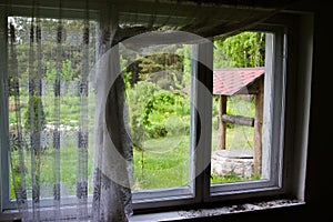 Old well seen through a rustic window