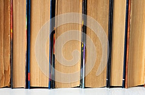 Old and well used hardback books or text books in a book shop or library. Many Books Piles. Hardback books. Back to school