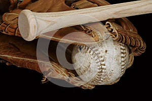 Old and Used Leather Softball and Glove with a Wood Bat