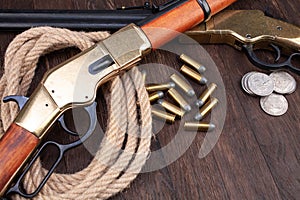 Old west gun - lever-action repeating rifle with ammunition and silver dollar coins