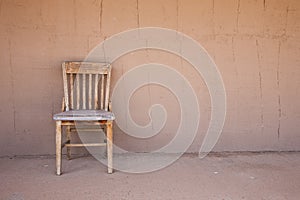 Old western chair against an adobe wall