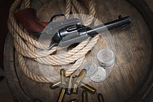 Old western revolver with cartridges and silver dollar